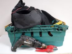 A holdall and crate containing hand tools and power tools