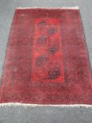 A Bokhara design rug on red ground,
