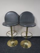 A pair of leather upholstered bar stools on chrome bases