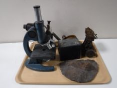 A tray of vintage blowtorch, live steam engine component, a Canco microscope, a fossilized husk,