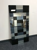 A contemporary all glass multi tone wall mirror