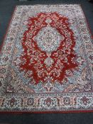 A Persian design machine made rug on red ground