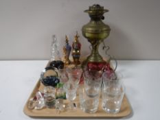 A tray of brass oil lamp base, assorted glass ware, decanters,