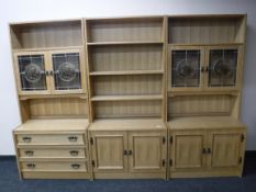 A three part oak bookcase with cabinets and drawers below