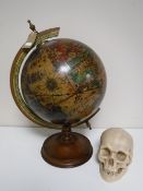 A wooden globe on stand and a resin skull