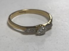 An 18ct gold diamond ring, the central stone approximately 0.2ct, size N/O, 2.3g.
