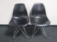 A pair of Vitra Eames black leather chairs on chrome legs,