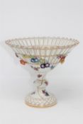 A continental porcelain pedestal fruit bowl, with blue crossed swords mark to base, height 19cm.