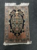 An Indian Kashmir silk finished rug, of floral design on blue ground.