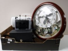A box containing a Small World Rhythm quartz wall clock, Lervia electric sewing machine (no pedal),