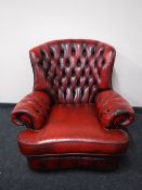 An oxblood buttoned leather Chesterfield armchair