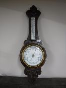 A carved oak cased barometer