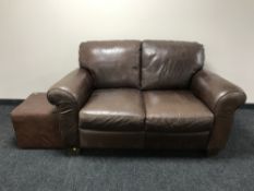 A brown leather two seater settee together with a non-matching foot cube