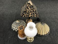 A brass oil lamp with glass chimney and shade, Tiffany style table lamp, two further shades,