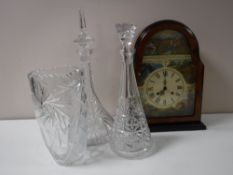 A contemporary mantel clock depicting wildlife, two lead crystal decanters with stoppers,