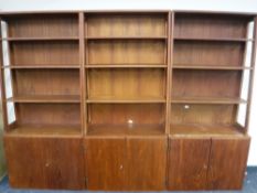A triple section Danish teak bookcase fitted cupboards beneath
