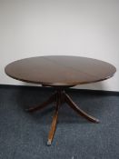A mahogany Regency style circular extending pedestal dining table