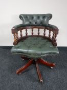 A green buttoned leather captains style swivel armchair