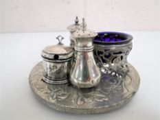A four piece sterling silver cruet set with blue glass liners on stand