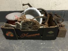 A box containing late 19th and 20th century metal ware including three large weights, cogs,