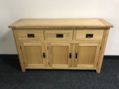 A contemporary triple door sideboard fitted three drawers