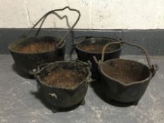 A set of four graduated cast iron cauldrons