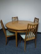 A circular teak G-plan dining table together with a set of four rail back chairs