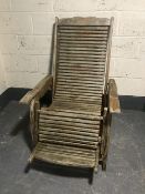 A pair of plantation teak reclining garden armchairs with foot rests