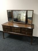 A Stag Minstrel six drawer dressing chest with triple mirror in a mahogany finish
