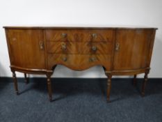 A shaped mahogany sideboard on reeded legs