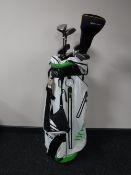 A Hugo Boss golf bag containing a set of Slazenger golf clubs and a pair of army desert books