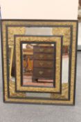 A 19th century ebonised and parcel gilt repousse framed mirror, height 74cm.