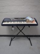 A Yamaha PSR-240 electric keyboard on stand with booklet