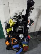 A golf bag containing assorted clubs together with three child's golf bags containing clubs