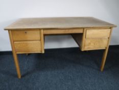 A mid 20th century oak desk fitted with four drawers