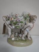 A continental bowl with flower decoration surmounted on three cherubs,
