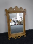 An antique pine Chippendale style mirror together with an oval mahogany bevelled edge mirror
