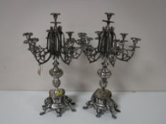 A pair of white metal candelabrum on stands