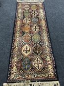 A fringed runner of geometric design on blue ground