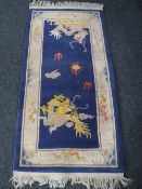 A fringed Chinese rug on blue ground