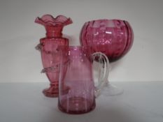 An antique cranberry glass jug and vase with later cranberry glass bowl