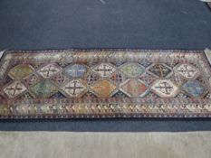 A fringed runner of geometric design on blue ground