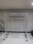 Three chrome portable clothes rails and a contemporary headboard