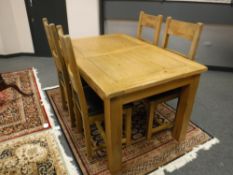 A contemporary oak extending dining table with four high backed chairs