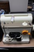 A cased Frister Rossman electric sewing machine