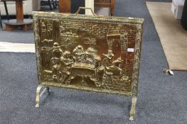 A brass embossed fire screen