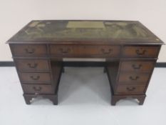 A mahogany twin pedestal writing desk with inset green leather panel