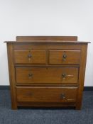 An Edwardian oak four drawer chest