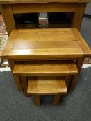 A contemporary oak nest of three tables