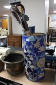 A brass coal bucket together with a bundle of two shooting sticks and a walking stick and a blue